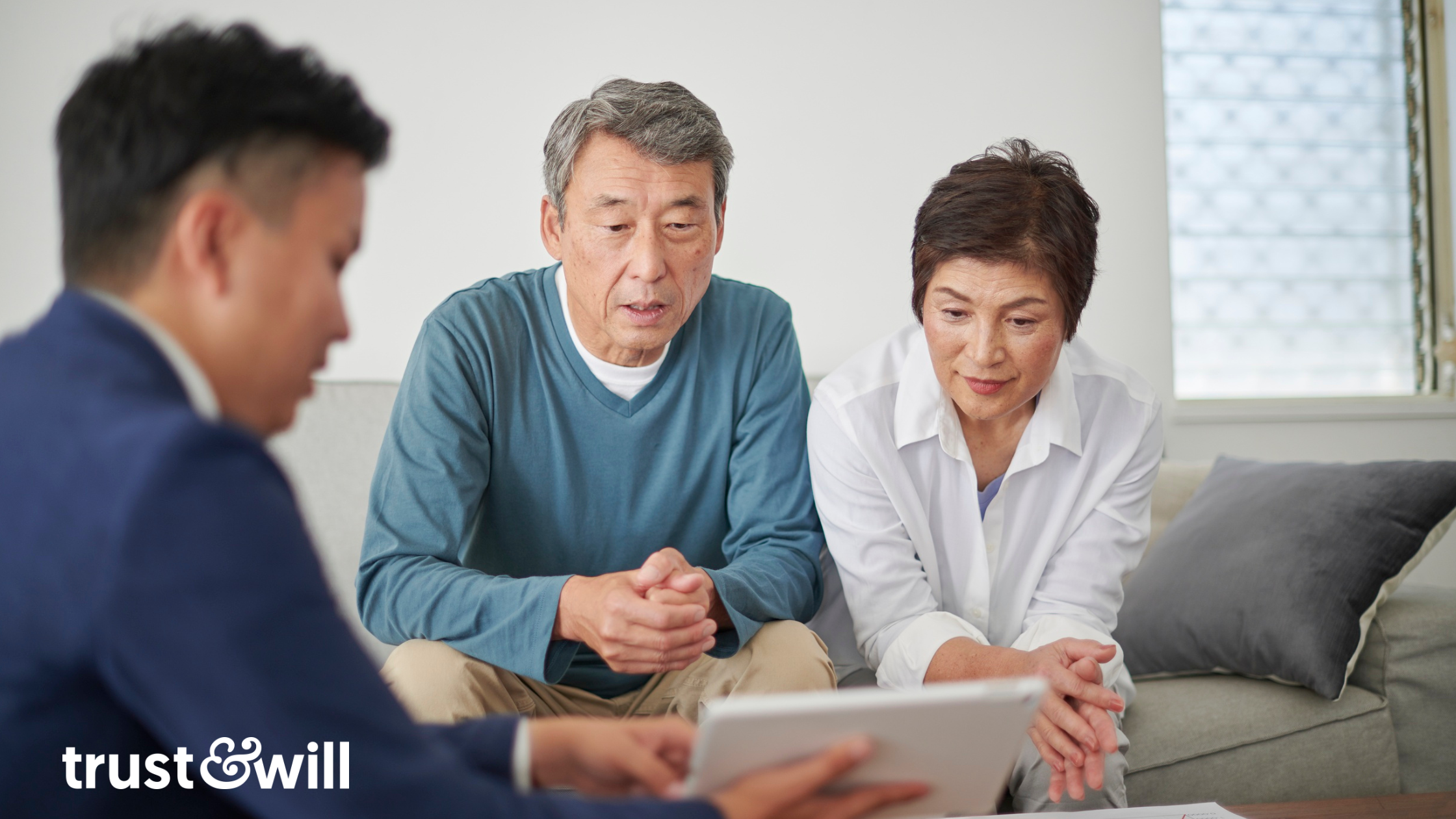 Couple sits on couch with consultant to go over estate planning